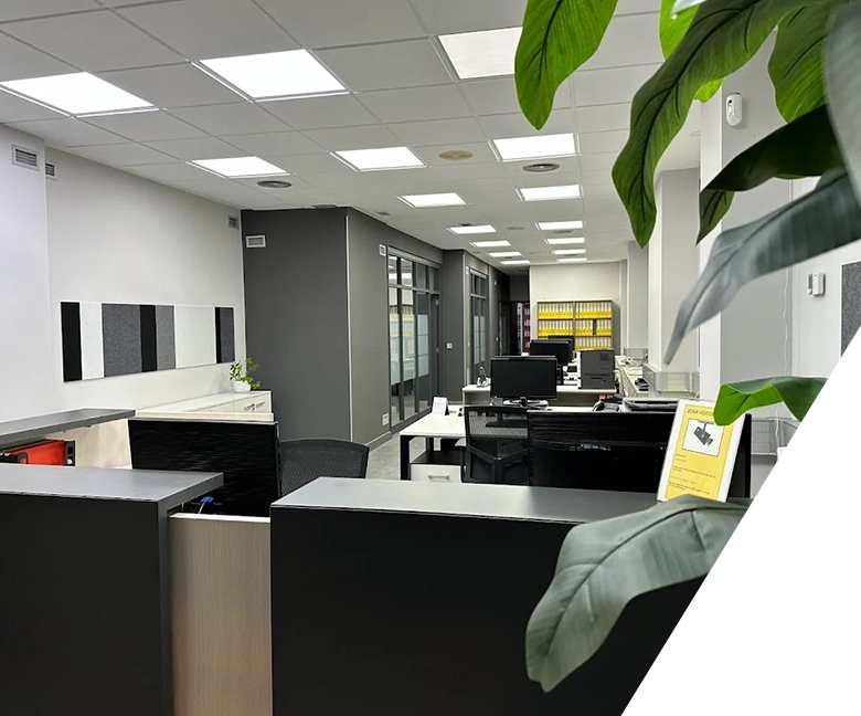 foto recepción con mesas y despacho al fondo