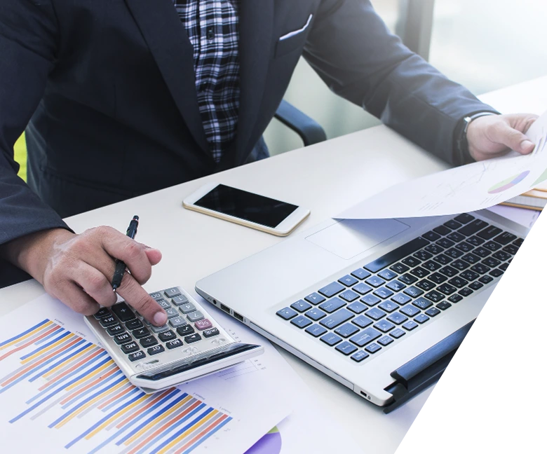 manos con calculadora, portátil y papeles